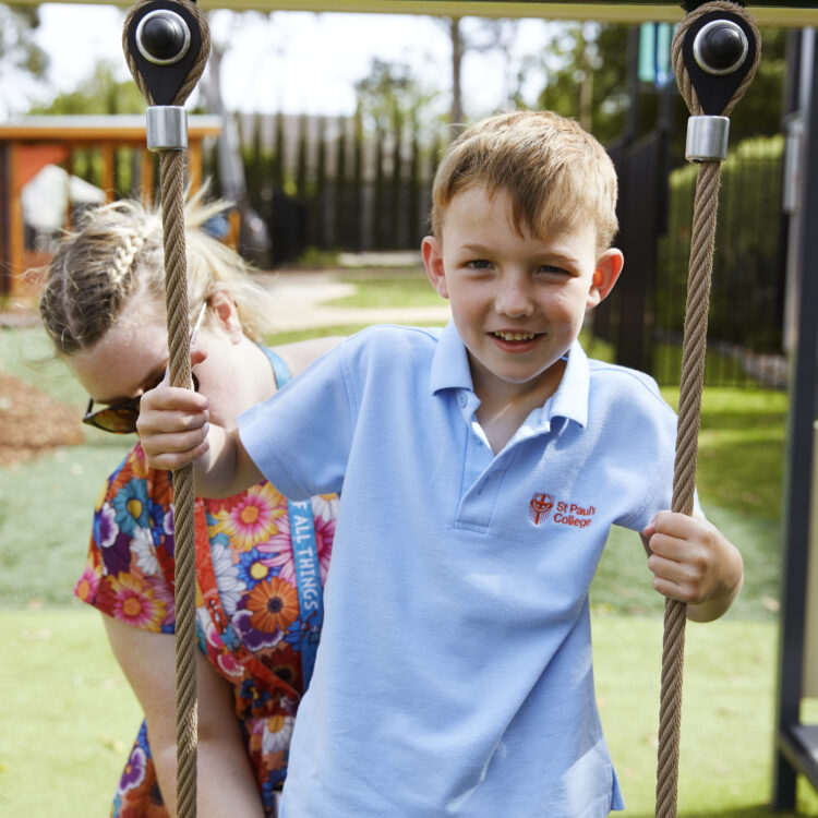 Image of a mother pushing her son on a swing