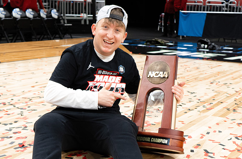 RARE Scholars program alum Carson Cook with an NCAA basketball trophy