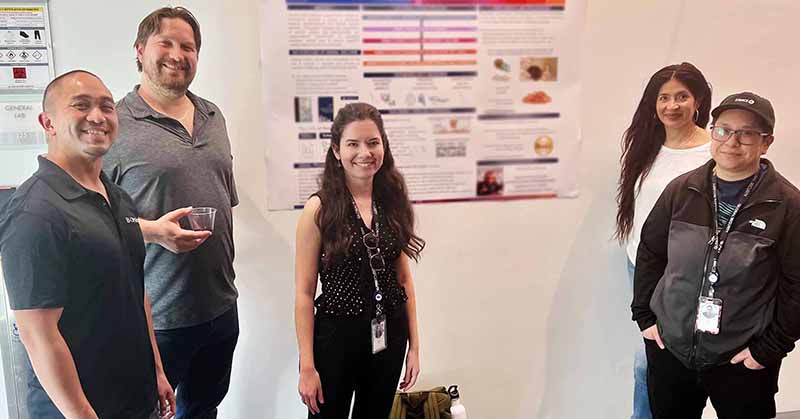 Five BioMarin researchers with a scientific poster