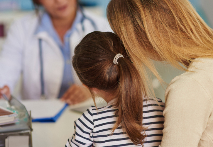 A healthcare provider consults with a caregiver and child.